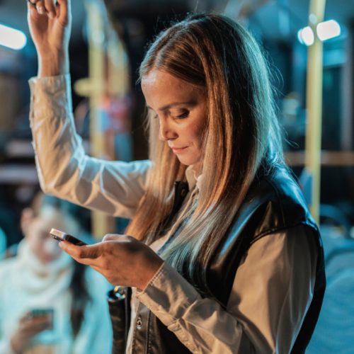 young-woman-using-smartphone-while-standing-on-eve-2024-09-05-20-42-29-utc (1)